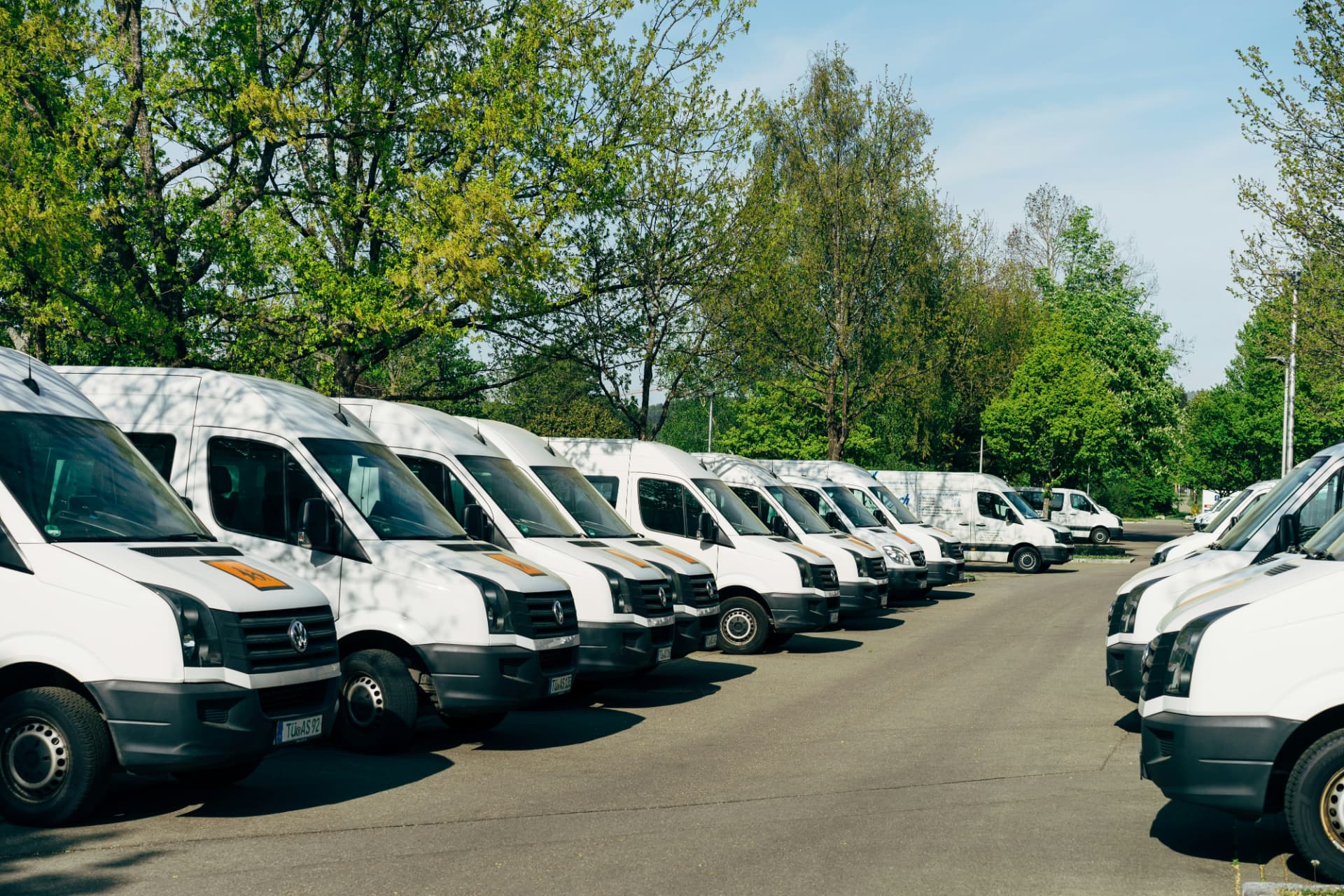 Commercial fleet vehicles - fleet management software pricing comparison Row of white commercial vans parked in a fleet lot